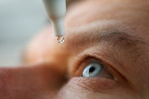 Man drops eye drops into eye for recalled eye drops blog post