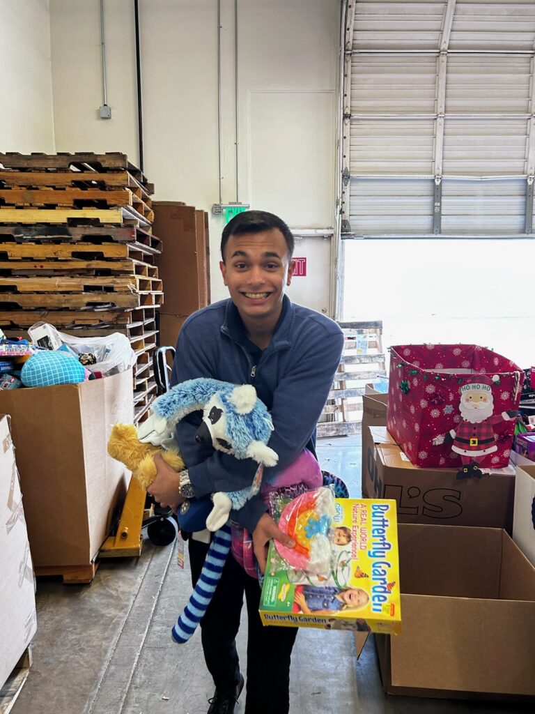 volunteer holding toys volunteering with Arizona Helping Hands