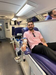 man giving blood in a bloodmobile for blood drive blog post