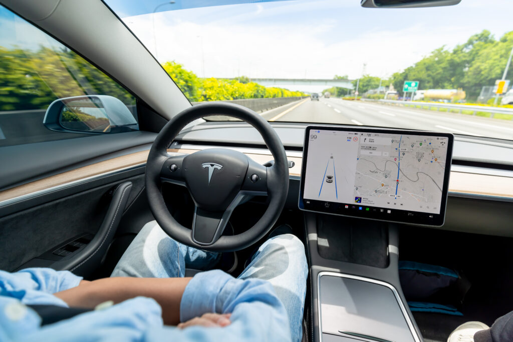person behind wheel of "self-driving" car for tesla recall blog post
