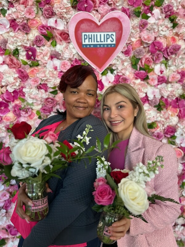 two employees at phillips law group flower shop event