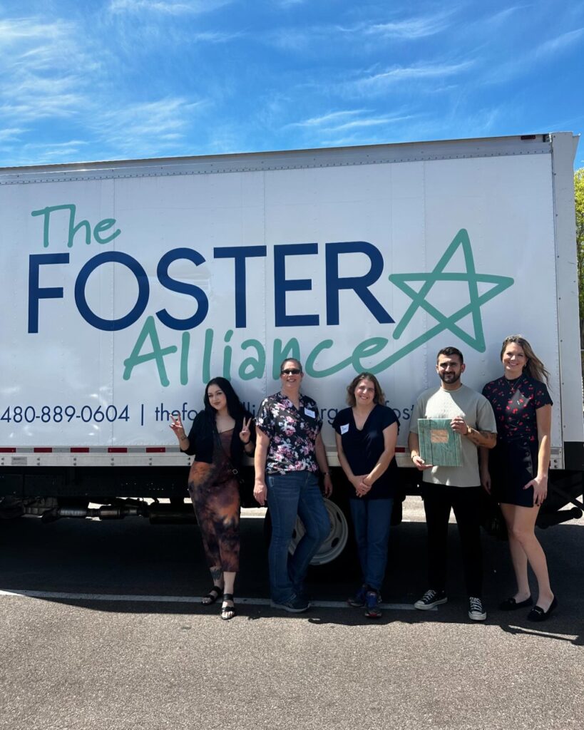 several volunteers pose outside of the foster alliance as part of phillips law group's active community service schedule in april