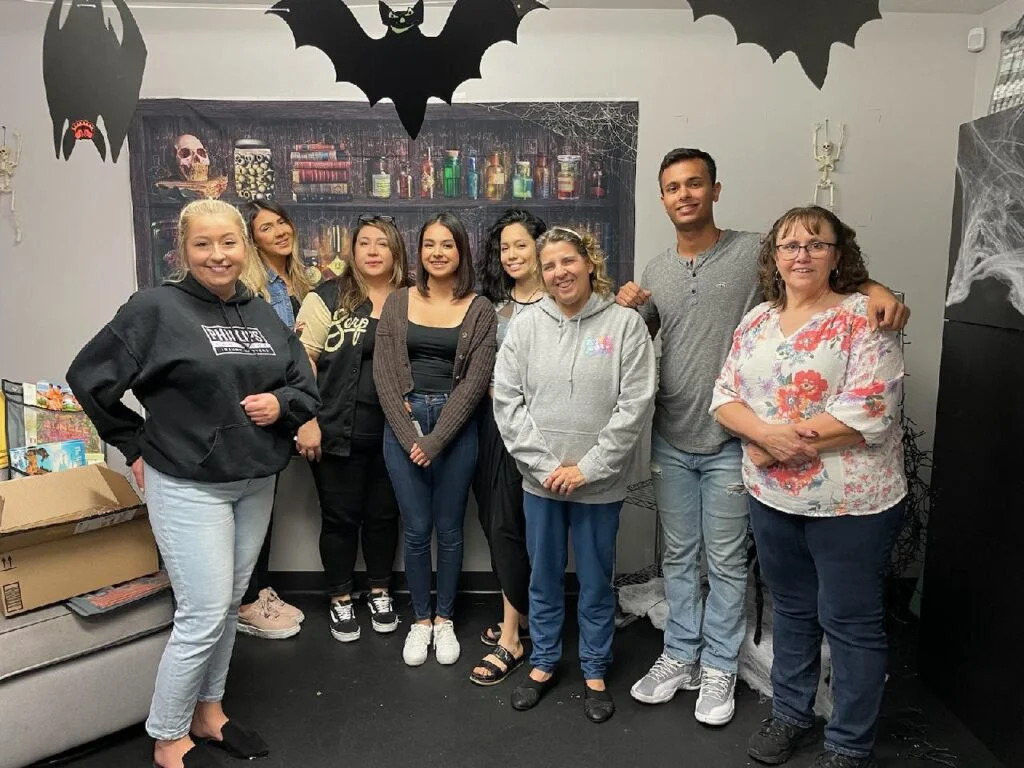 volunteers at community service event in a room decorated for halloween