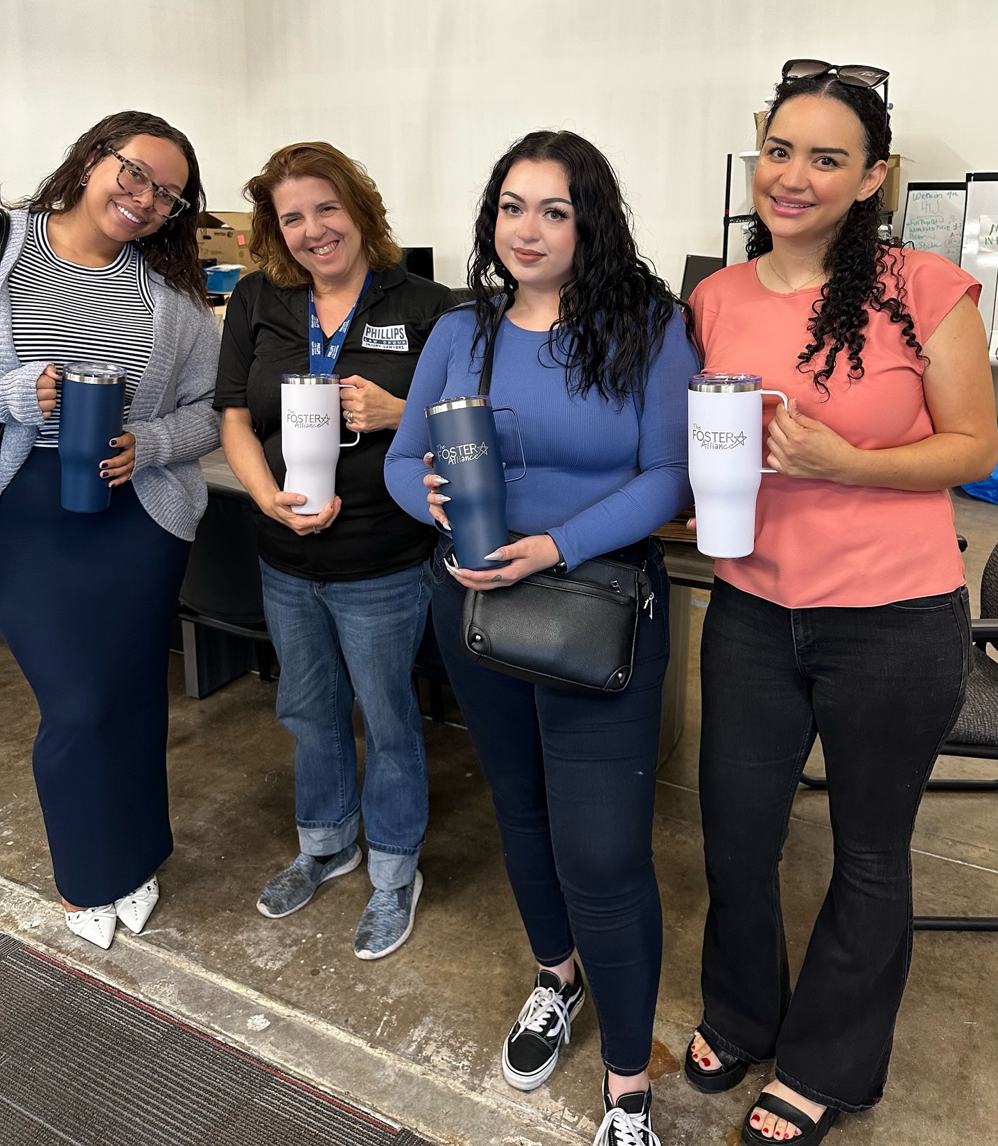 four volunteers pose with tumblers from new volunteers assist with community outreach blog post