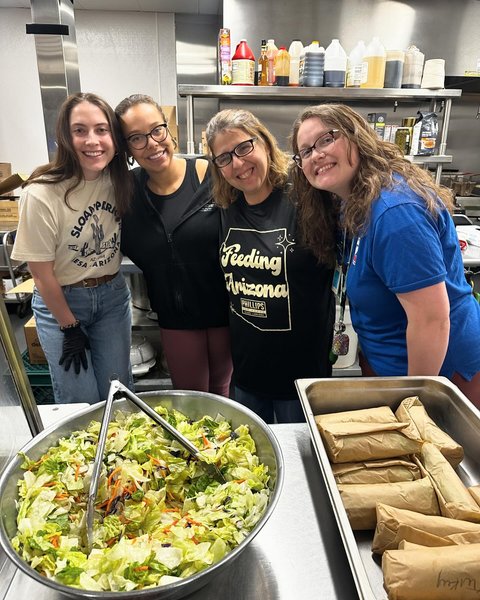 volunteers pose with food for volunteer opportunities in may blog post