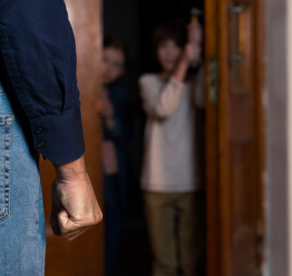 close-up of a clenched fist and two children in the background