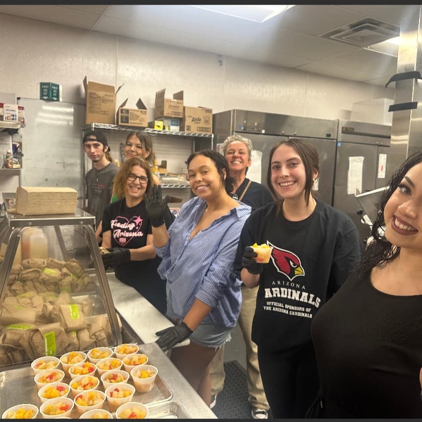 volunteers pose in kitchen at mana house father's day brunch event