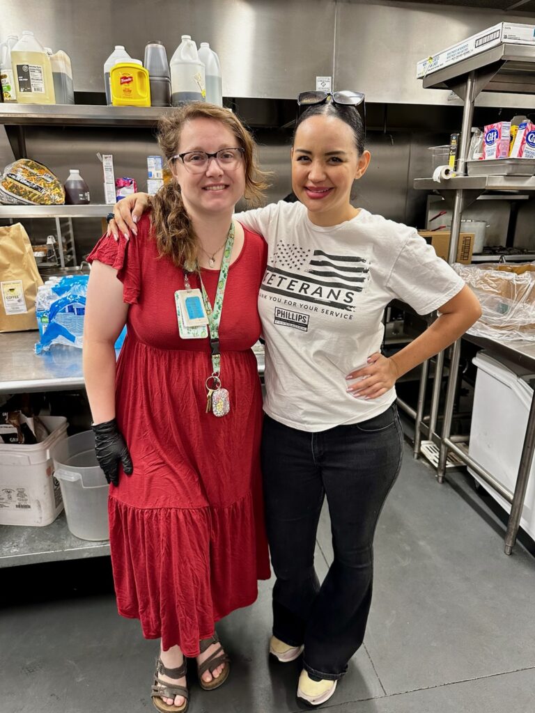 two volunteers pose in kitchen at mana house father's day brunch event
