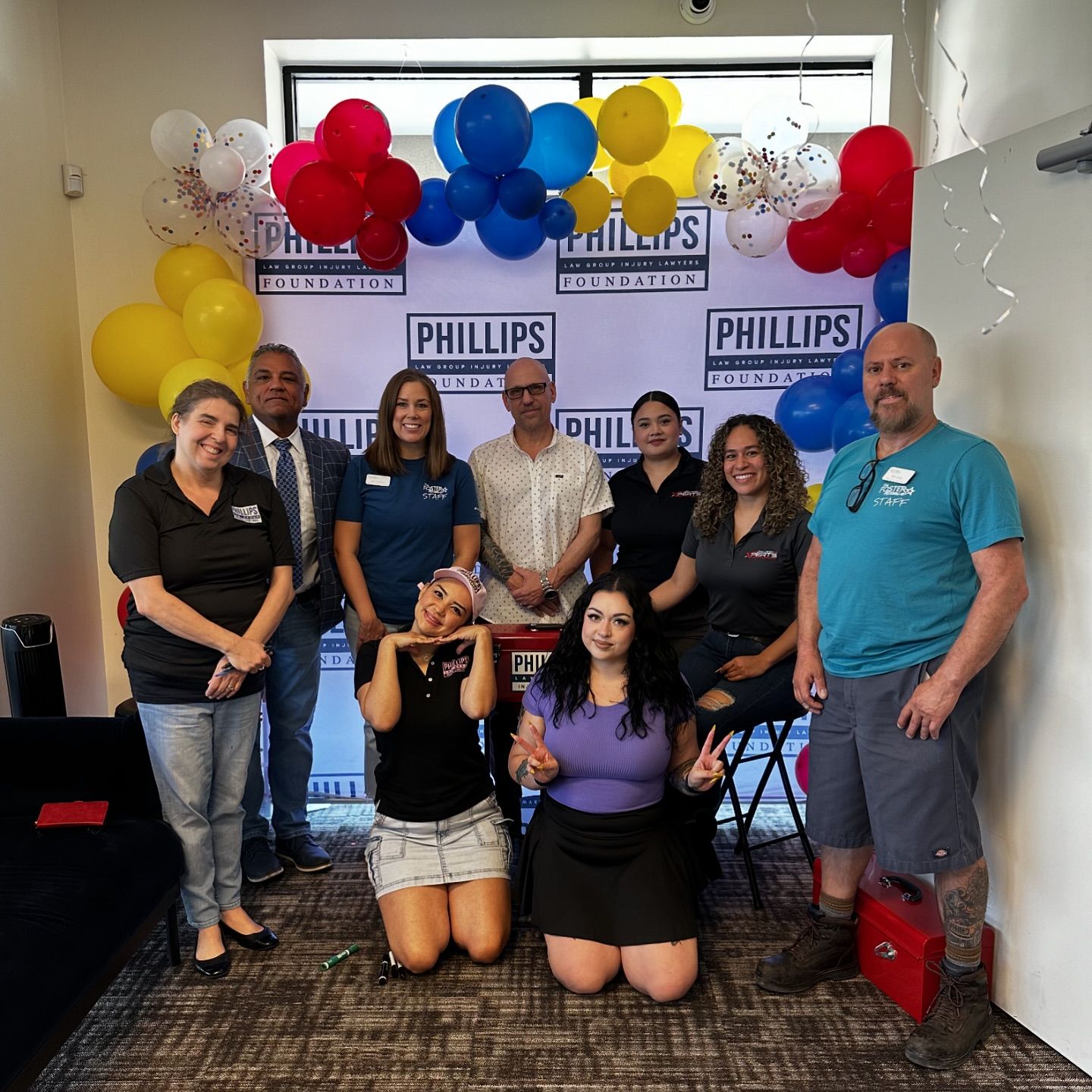 several volunteers pose with banner at foster alliance back to school event in mesa