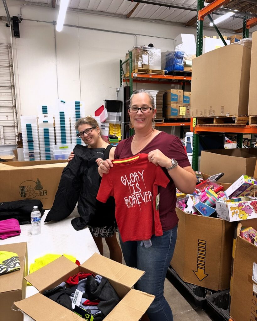 two volunteers sorting clothes at the foster alliance