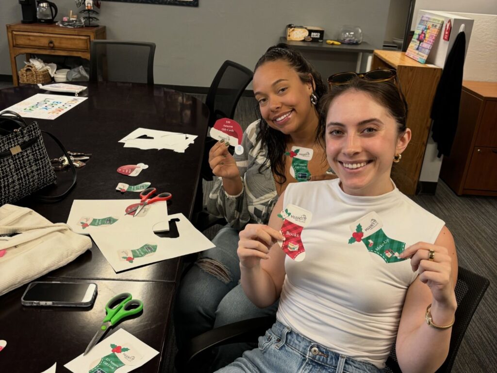two volunteers with christmas ornaments they helped make at maggie's place
