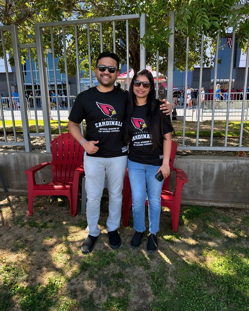 two individuals posing in phillips law group shirts at football game