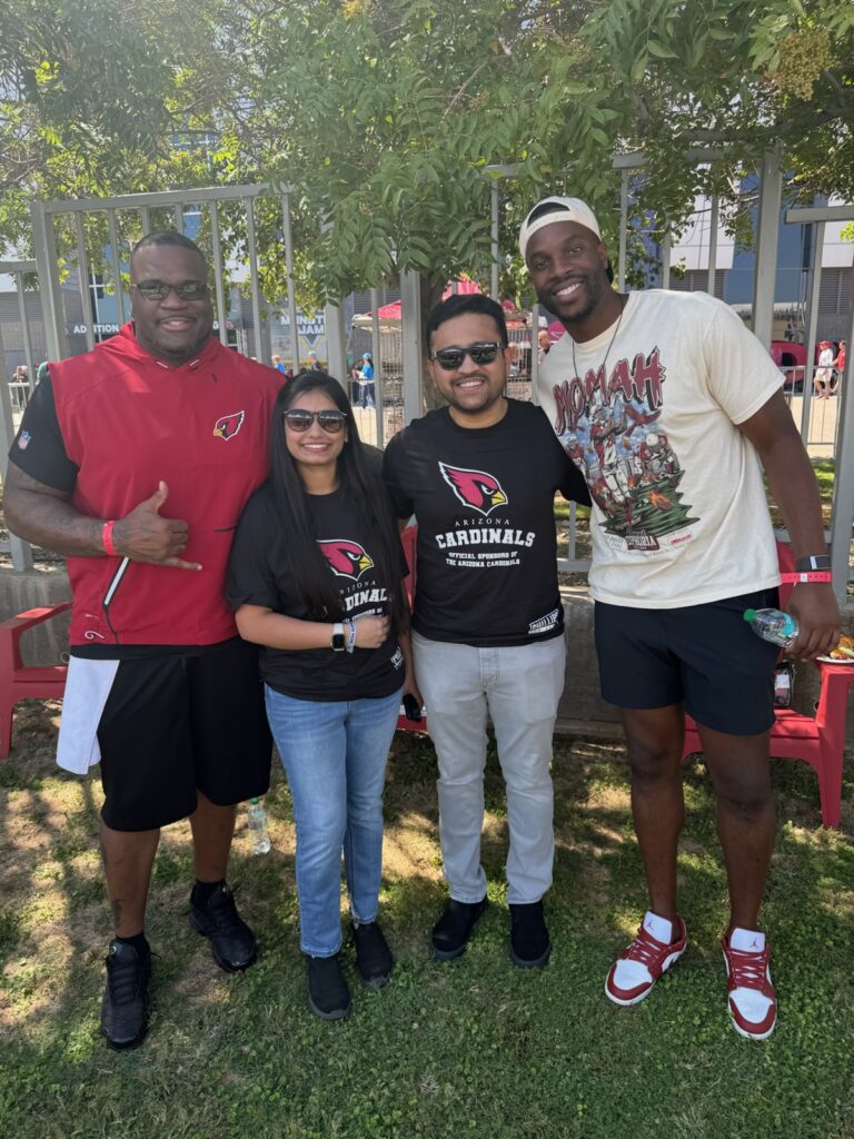 four people posing happily at arizona cardinals football game tailgate event