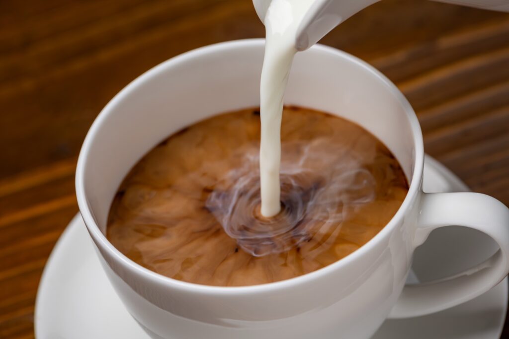 creamer being poured into coffee