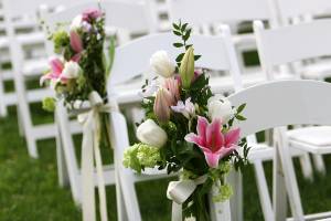 flowers on chairs at outside wedding
