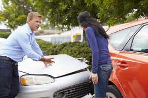 man and woman arguing after car crash