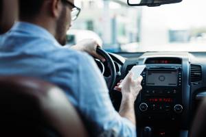 driver behind the wheel looking at smartphone