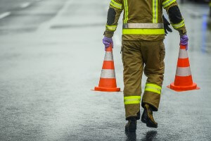 emergency worker carrying cones on highway