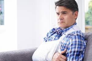 man with arm in sling looking concerned