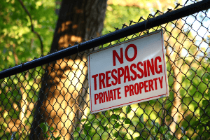 trespassing sign attached to fence