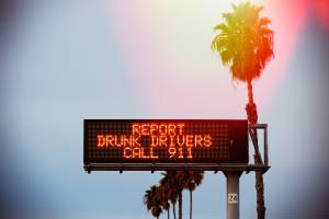 daytime shot of road sign warning to report drunk drivers