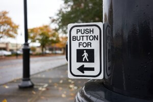 pedestrian pushing crosswalk button